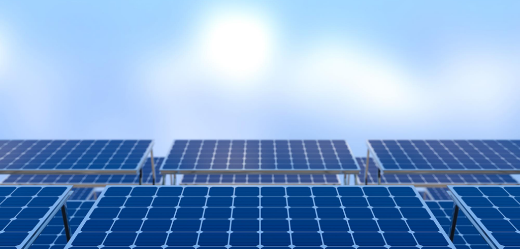 Close-up of rows of blue photovoltaic solar panels mounted on metal frames under a bright blue sky.