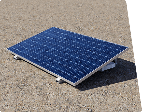 A tilted blue solar panel with white and grey mounts rests on a gravel surface, casting a shadow.
