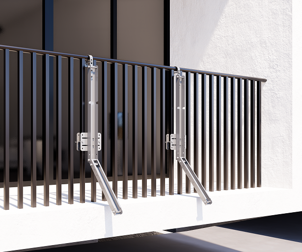 Two silver metal mounting brackets hooked onto a dark balcony railing with vertical balusters.
