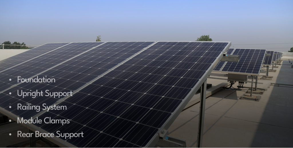 Rows of black solar panels mounted on a tilted racking system on a flat surface under a clear sky.