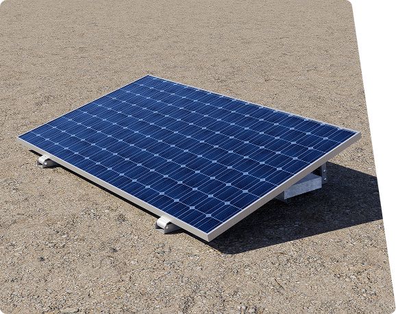 A tilted blue solar panel with white and grey mounts rests on a gravel surface, casting a shadow.